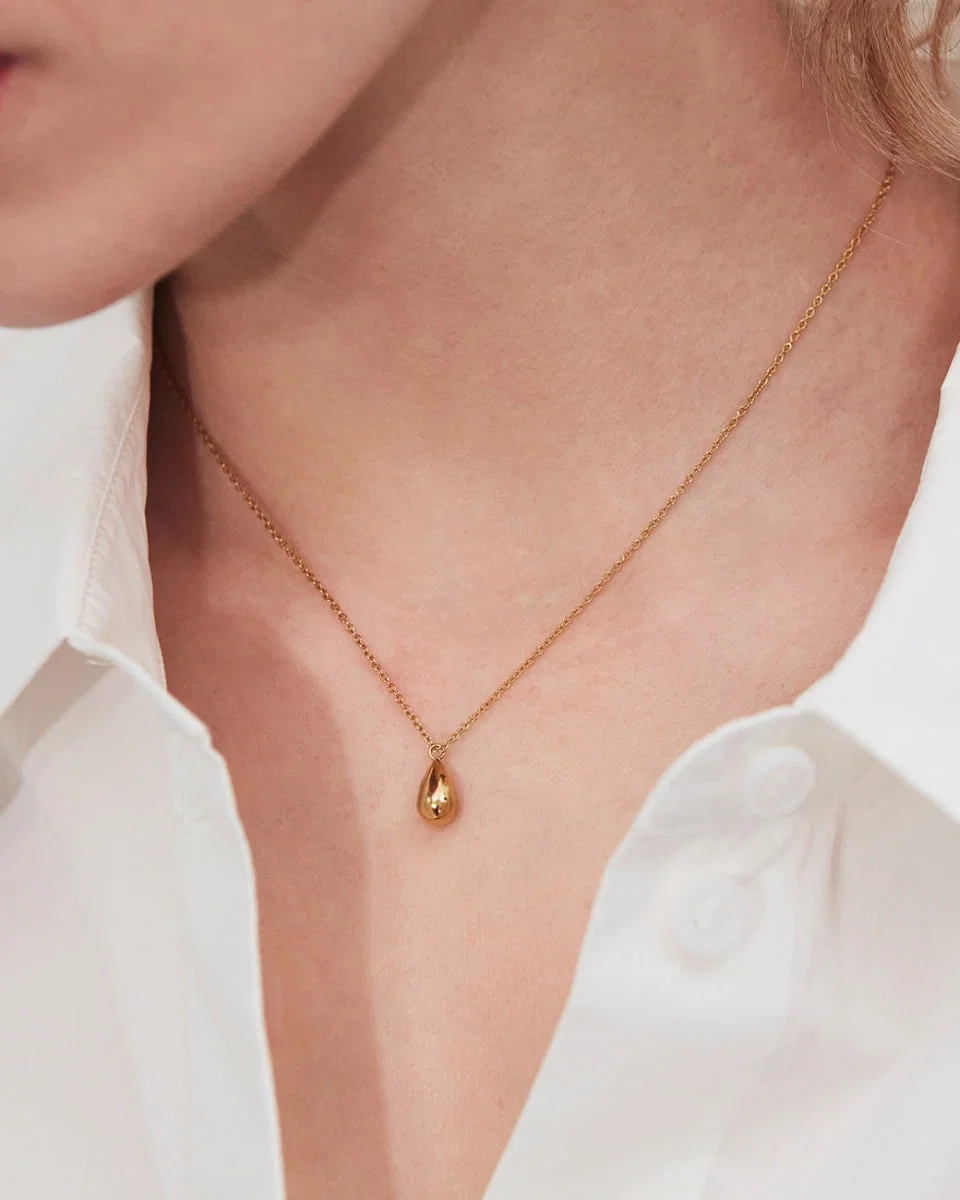 Kullattu Edblad Drop Mini Necklace Gold -kyynelkaulakoru mallin kaulalla