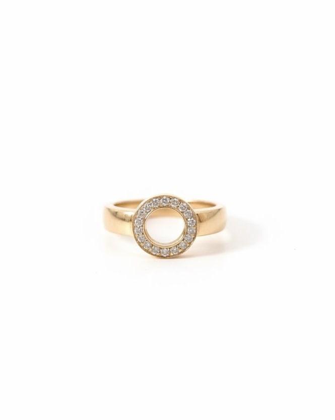 Närbild på Efva Attling Ring On Ring vigselring framifrån, där 17 diamanter bildar en rund cirkel med ett öppet center.