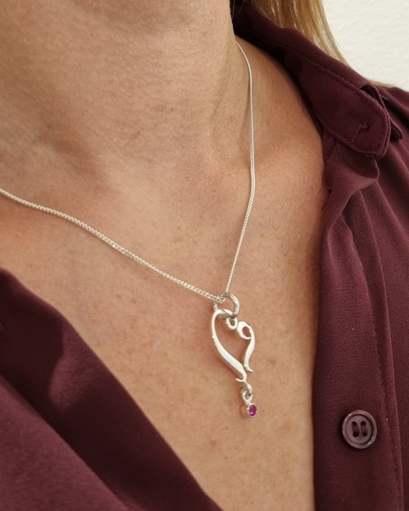 Guldviva Rubinhjärta halsband runt halsen: halsbandet sträcker sig över bröstet.