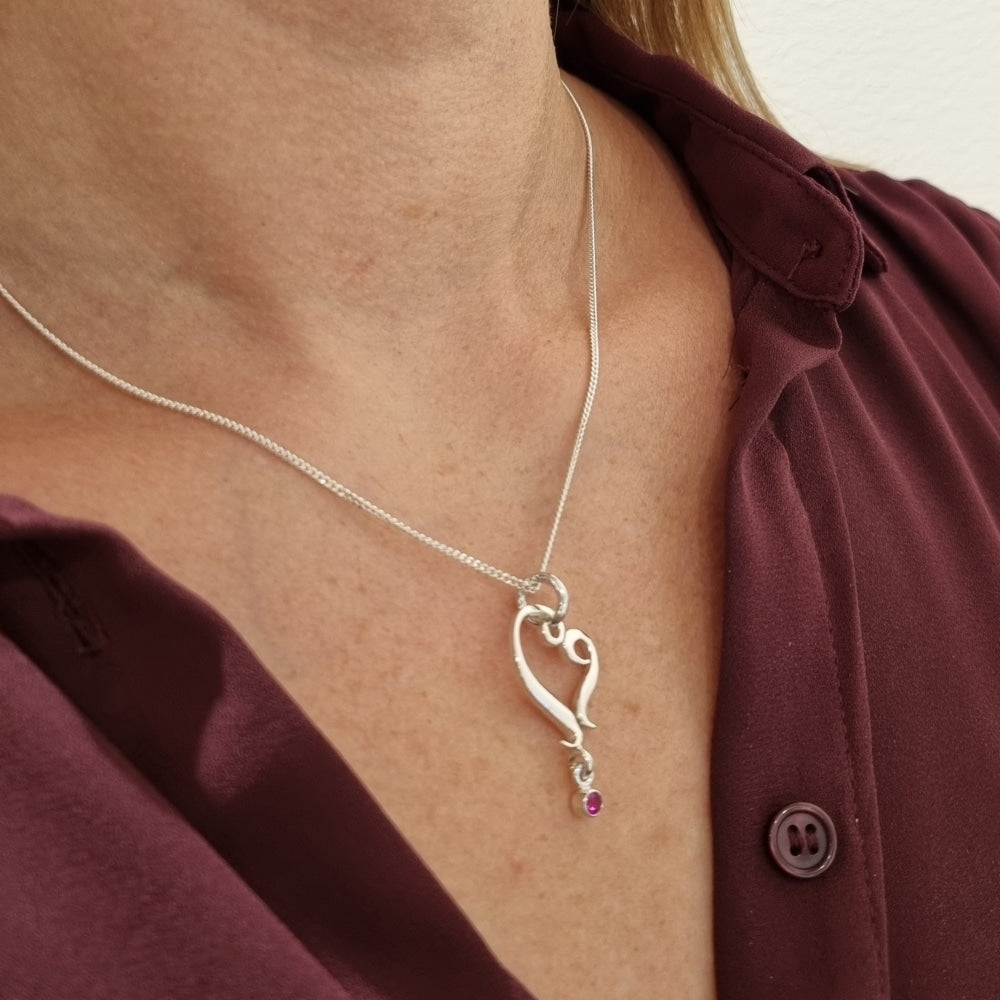 Guldviva Rubinhjärta halsband runt halsen: halsbandet sträcker sig över bröstet.