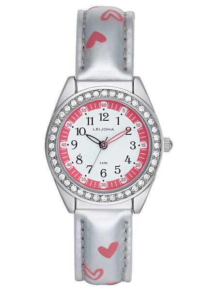 Leijona Junior Heartz White 5323-967 barnklocka har en rund, vit och rosa urtavla med svarta numeriska index och svart och rosa visare. Ramen är dekorerad med strass. Boetten och remmen är silverfärgade och det finns rosa hjärtan på remmen.