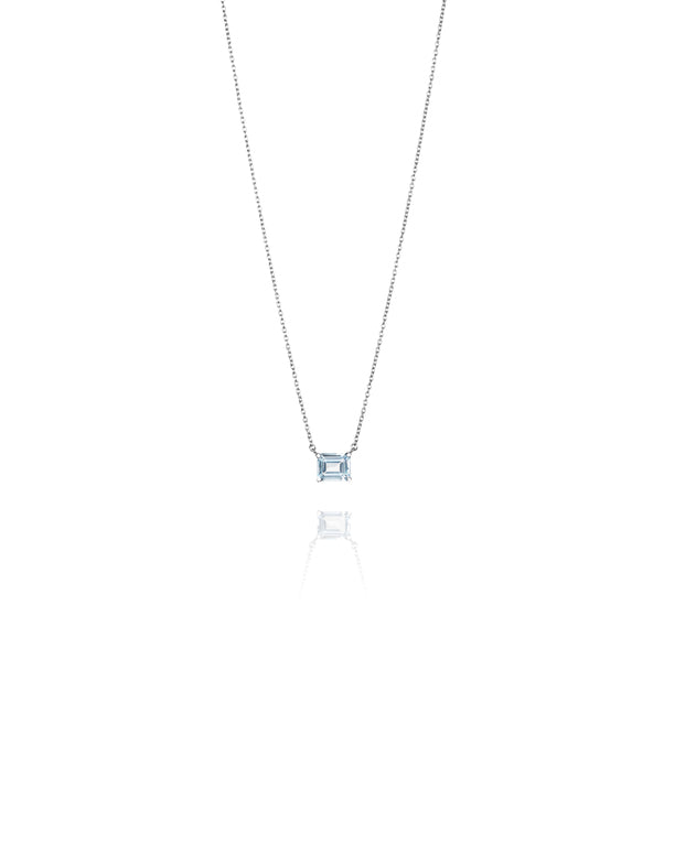 Efva Attling A Macaron Dream 10-100-01503 halsband har en tunn rhodinerad ankarkedja fäst vid en genomskinlig ljusblå smaragdslipad topas