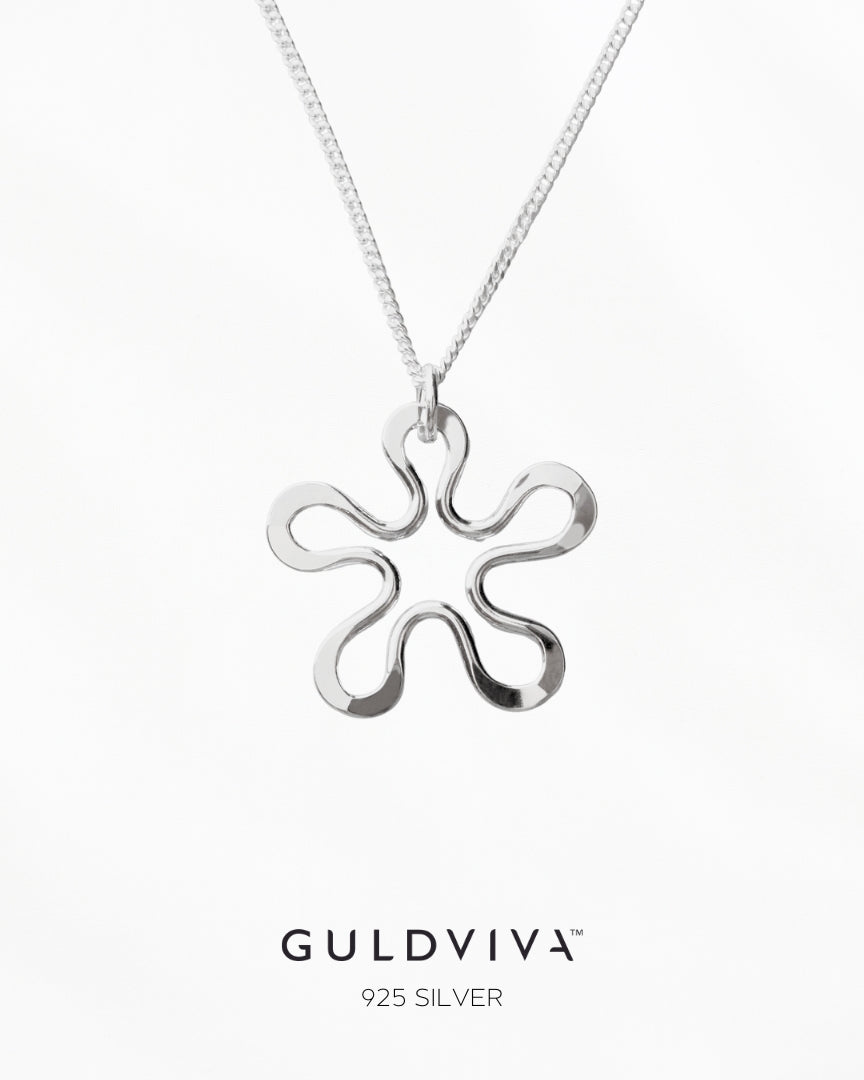 Guldviva Blomman™ halsband har en tunn silverkedja. Hänget är ett stiliserat blommönster.