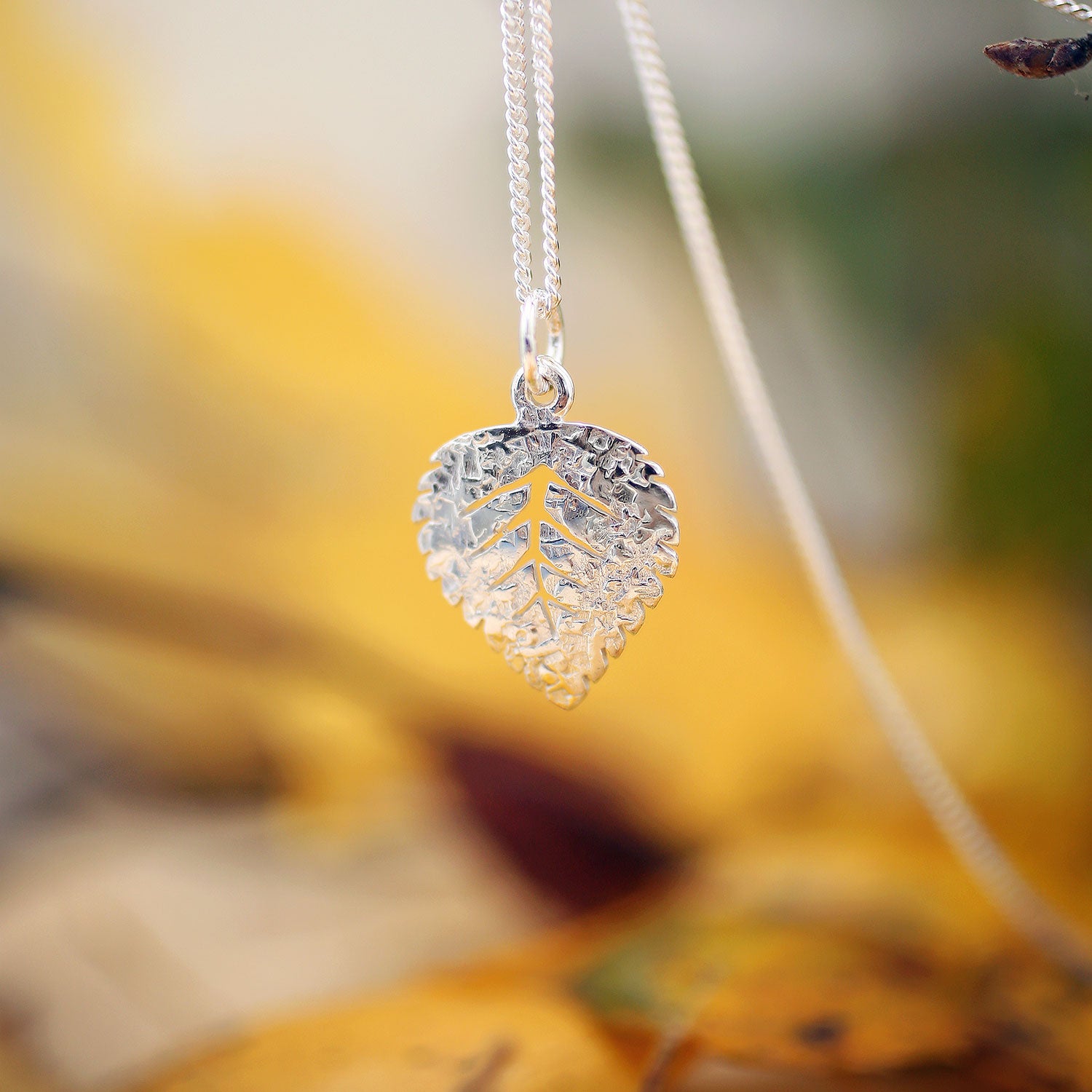 Guldviva Björk XS halsband har en tunn silverkedja. Hänget ser ut som ett björklöv.