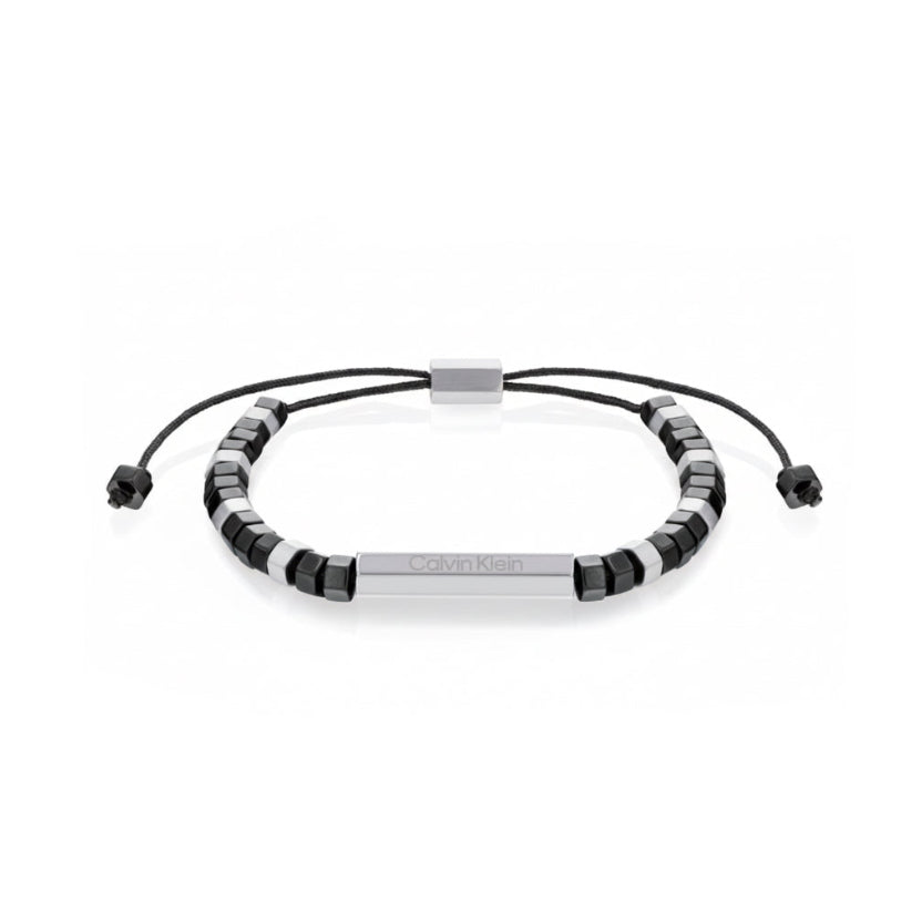 Calvin Klein Essential Shapes CKJ35000278-armbandet har svarta och silverfärgade sexkantiga stålpärlor. En silverfärgad pärla i mitten är längre än de andra och bär inskriptionen: "Calvin Klein".