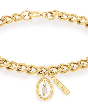 Calvin Klein Edgy Pearls CKJ35000561 armband har en guldfärgad länkkedja och ett hänge. Hänget har formen av en saltlakrits och har en pärla i mitten.