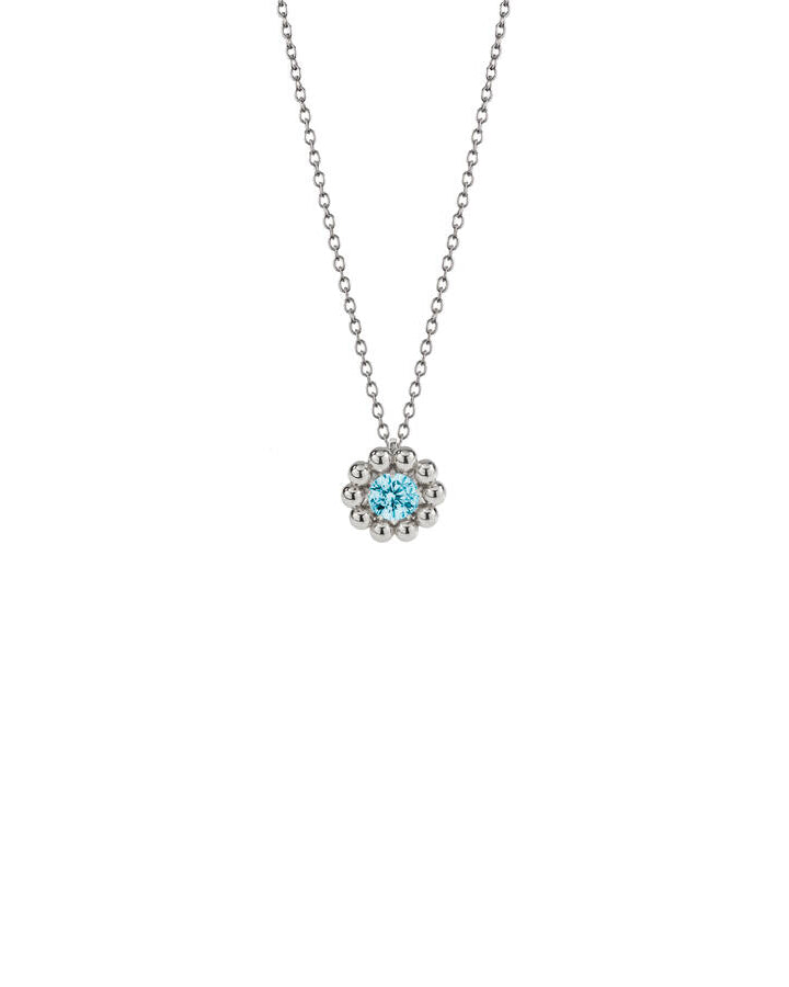 Lumoava Daisy-halsbandet har en tunn silverkedja. Hänget är som en blomma: i mitten finns en blå rund zirkon omgiven av små silverpärlor.