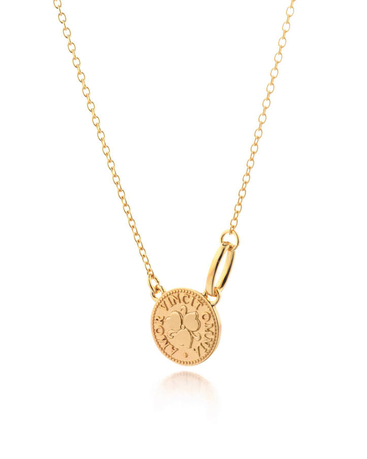 Lumoava Penny-halsbandet har en tunn, förgylld silverkedja. Hänget är ett runt mynt med texten: "Amor vincit omnia".