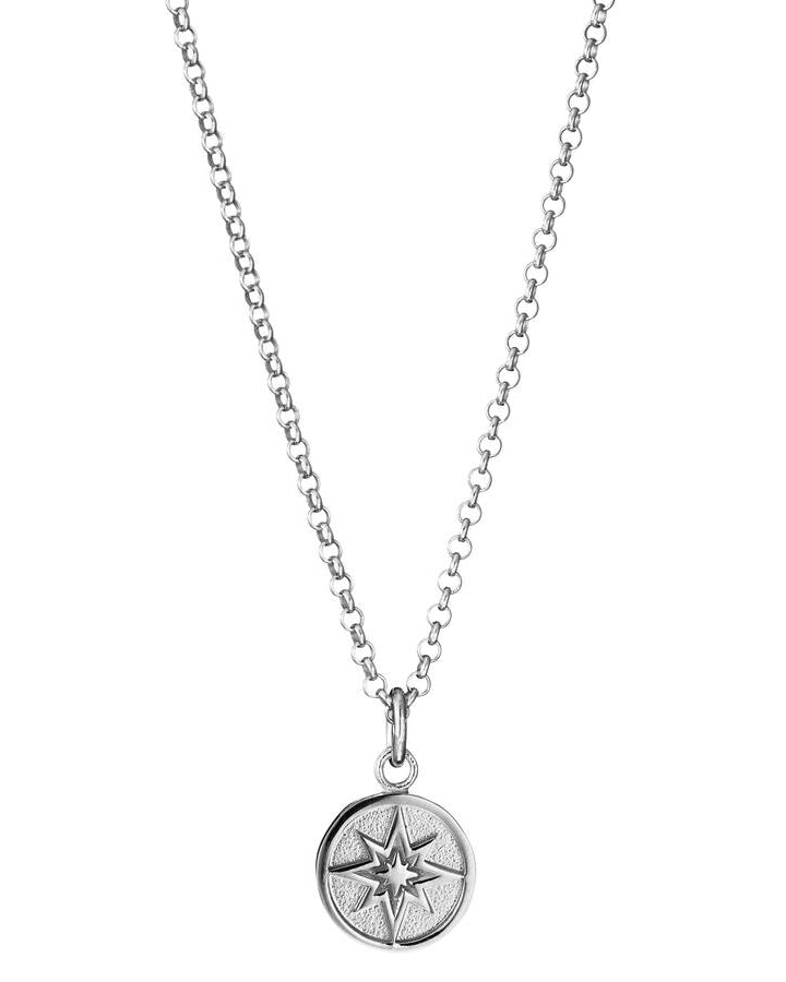 Lumoava Toivo-halsbandet har en tunn silverkedja. Hänget är runt och har ett mönster som liknar en stjärnkompass.