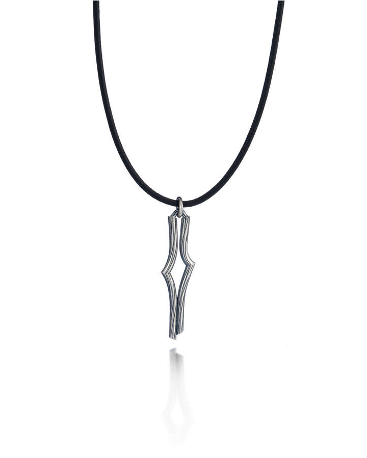 Lumoava Vaellus -halsbandet har ett tunt läderband. Hänget är geometriskt och strömlinjeformat, som en modern stig eller väg på en karta.