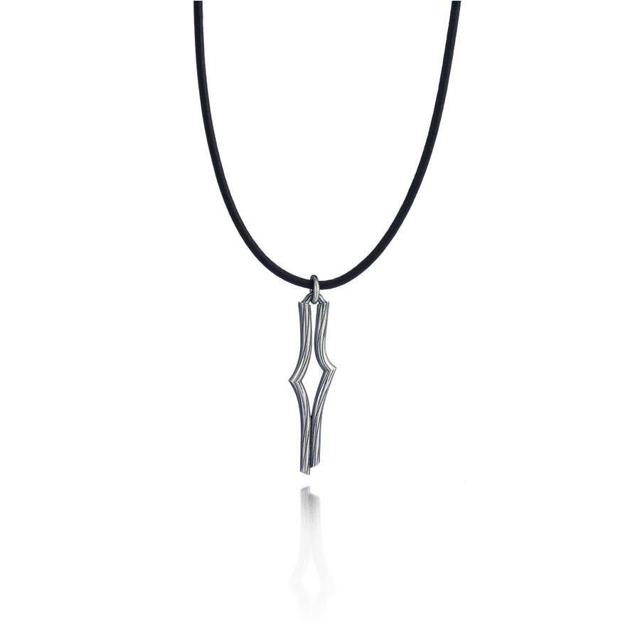 Lumoava Vaellus -kaulakorussa on ohut nahkanyöri. Riipus on geometrinen ja suoraviivainen, kuin moderni polku tai reitti kartalla.