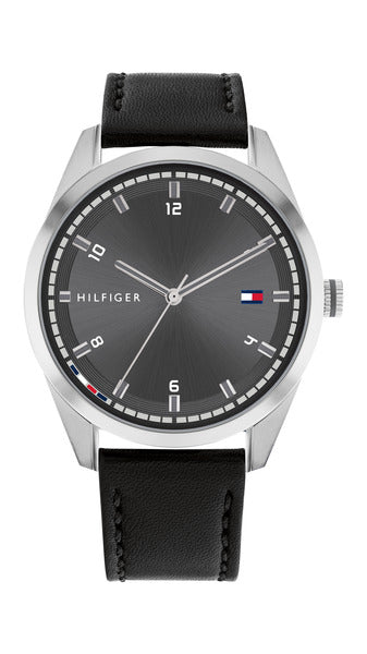 Tommy Hilfiger Griffin TH1710459 herrklocka har en rund, mörk grå urtavla med silverfärgade index och visare. Ramen och boetten är också silverfärgade. Remmen är en svart läderrem med svarta sömmar.