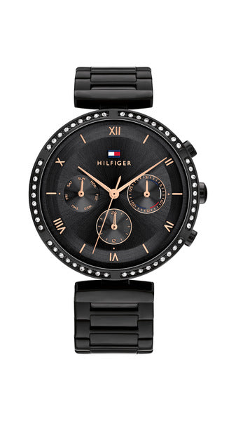 Tommy Hilfiger Luna TH1782390 damklocka har en rund, svart urtavla med datum-, veckodag- och 12/24h-visning samt roséguldfärgade romerska siffror och visare. Ramen, boetten och remmen är också svarta. Ramen är dekorerad med smyckestenar.