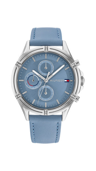 Tommy Hilfiger Ariana TH1782500 damklocka har en rund, ljusblå urtavla med datum-, veckodag- och 12/24h-visning samt silverfärgade index och visare. Ramen är silverfärgad och dekorerad med smyckestenar. Boetten är också silverfärgad. Remmen är en ljusblå läderrem med blåa sömmar.