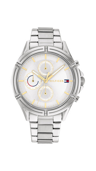 Tommy Hilfiger Ariana TH1782502 damklocka har en rund, silverfärgad urtavla med datum-, veckodag- och 12/24h-visning samt guldfärgade index och visare. Ramen är silverfärgad och dekorerad med smyckestenar. Boetten och remmen är också silverfärgade.