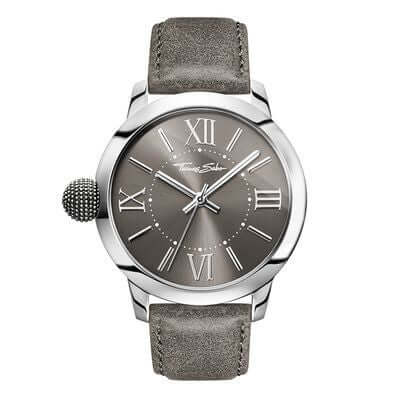 Thomas Sabo Rebel With Karma WA0294-273-210 herrklocka har en rund, grå urtavla med silverfärgade romerska siffror och visare. Ramen och boetten är också silverfärgade. Remmen är en grå läderrem med sömmar. Knoppen på klockan är en Karma Bead och den sitter på vänster sidan av klockan.