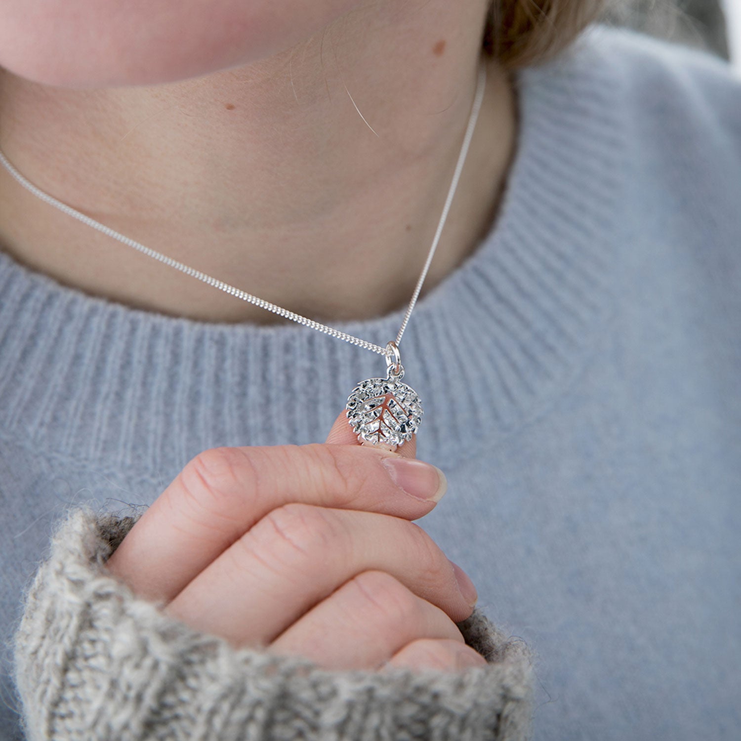 Hänget på Guldviva Björk XS-halsbandet är ungefär lika stort som en tumme.