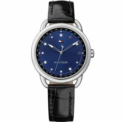 Tommy Hilfiger Lucy TH1781739 damklocka har en rund, mörkblå urtavla med stjärnor som index och silverfärgade visare. Urtavlan har också en svart kant med minutmarkerinar. Boetten är silverfärgade. Remmen är en svart läderrem med svarta sömmar.