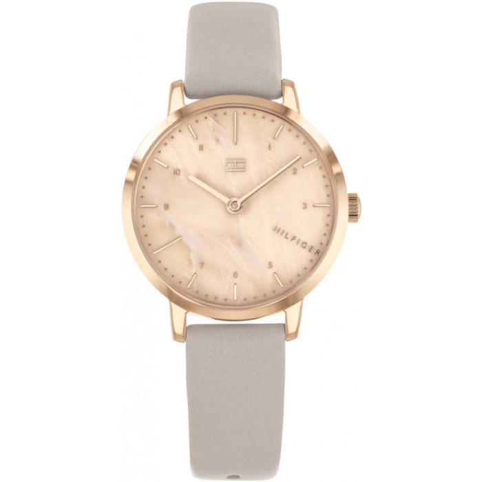Tommy Hilfiger Lily TH1782039 damklocka har en rund, roséguldfärgad urtavla med en yta som liknar marmor. Index, visare, ram och boetten är roséguldfärgade. Remmen är en grå läderrem utan sömmar.