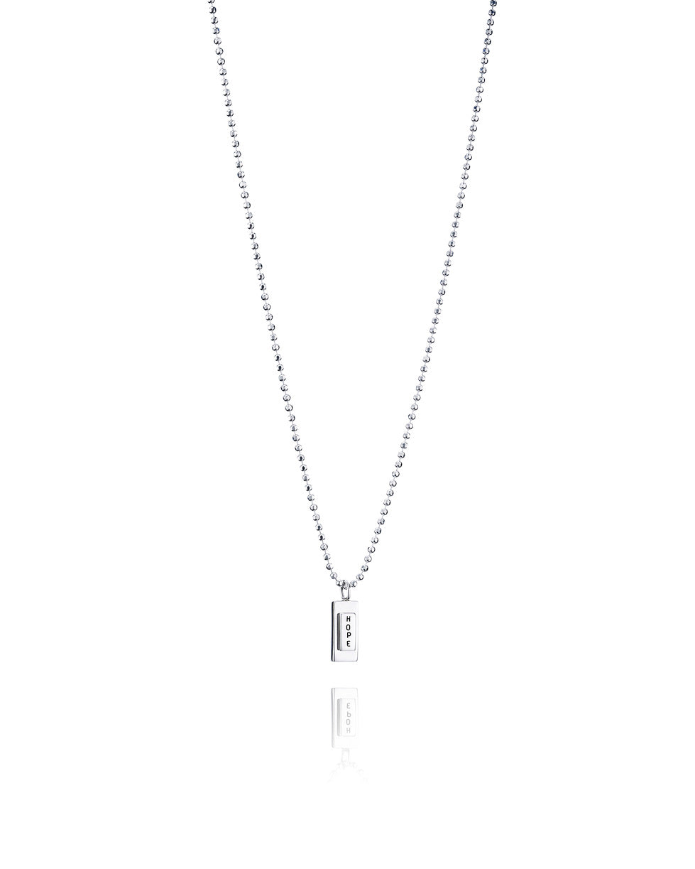Efva Attling Little Hope 11-100-00041 halsband har en tunn silverkedja. Hänget är en silverplatta med bokstäverna H, O, P och E under varandra