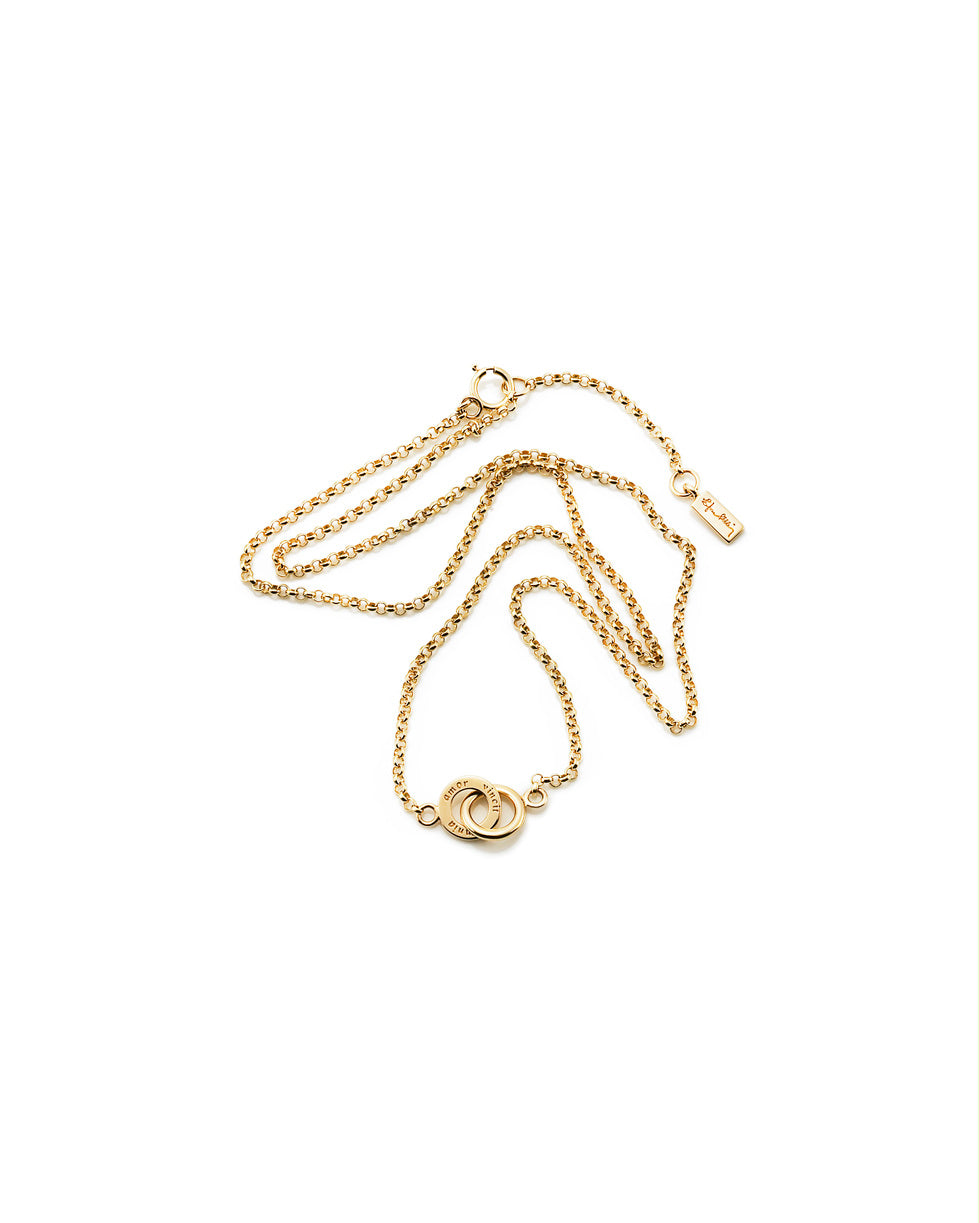 Efva Attling Mini Twosome 10-101-00565 halsband har en tunn guldkedja. Dekorationen består av två ringar som är kopplade till varandra. På en av ringarna finns inskriptionen: "AMOR VINCIT OMNIA".