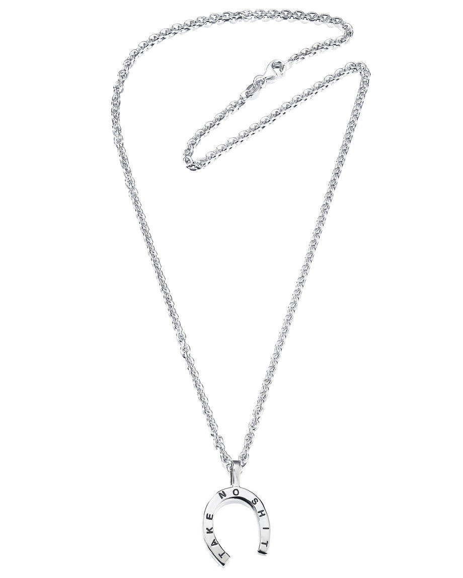 Efva Attling Take no Shit Large 11-100-00876 halsband har en tunn silverkedja. Hänget är en hästsko med texten "TAKE NO SHIT".