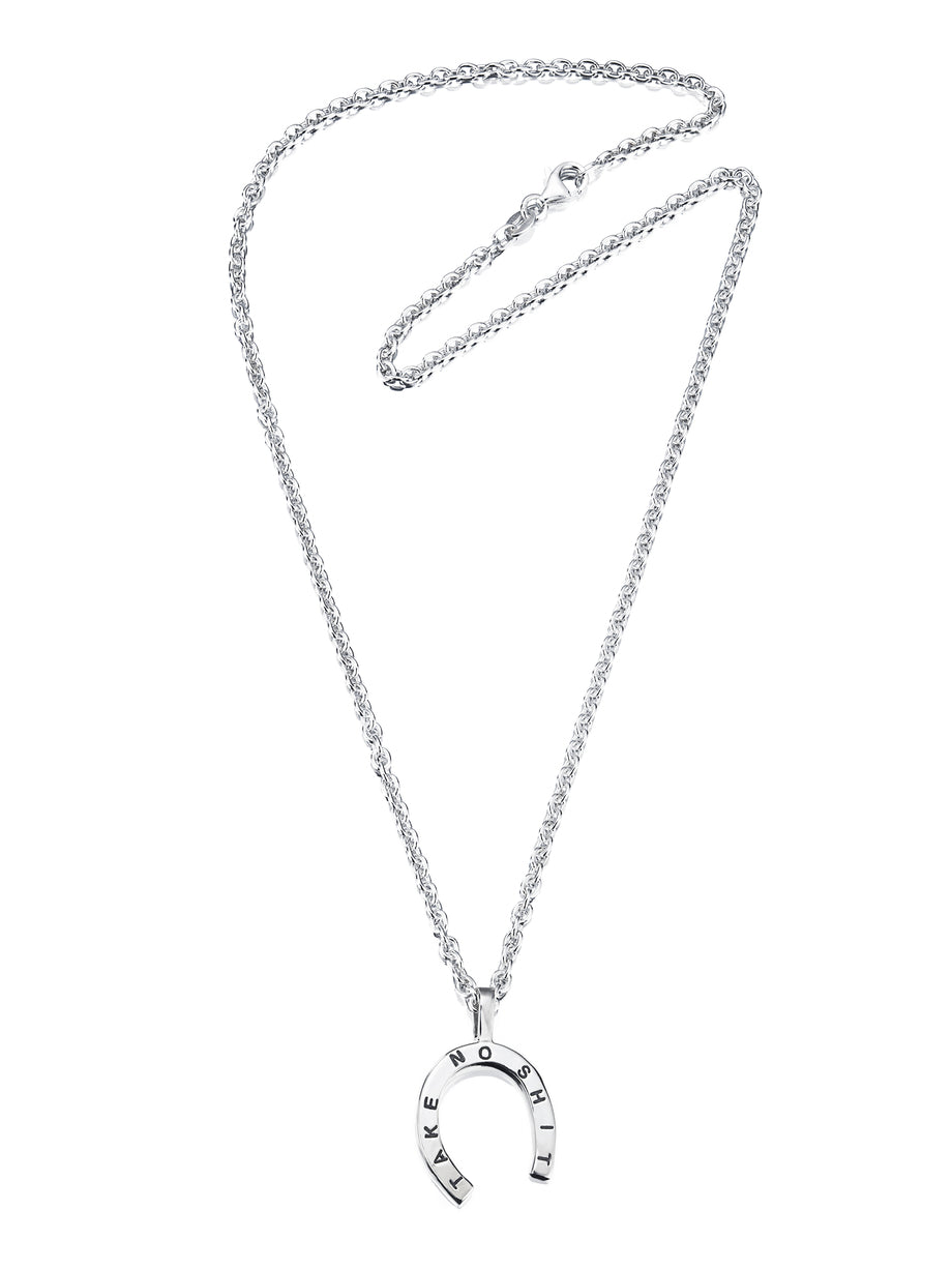 Efva Attling Take no Shit Large 11-100-00876 halsband har en tunn silverkedja. Hänget är en hästsko med texten "TAKE NO SHIT".