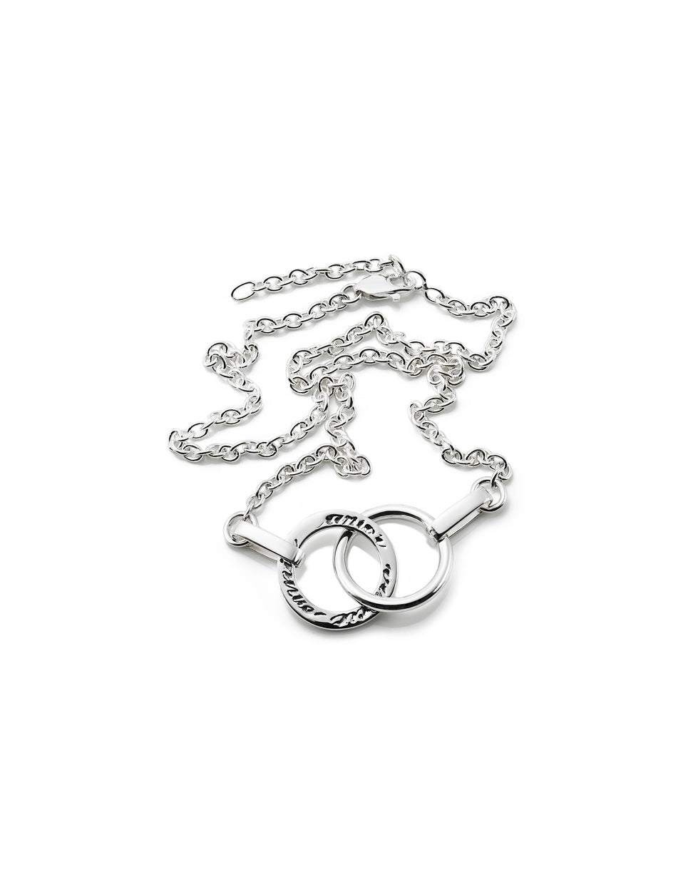 Efva Attling Twosome 10-100-00524 halsband har en tunn silverkedja. Dekorationen består av två ringar som är kopplade till varandra. På en av ringarna finns inskriptionen: "AMOR VINCIT OMNIA".