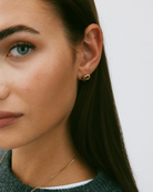 Kullatut Edblad Infinity Knot Studs S Gold -solmukorvakorut 129853 mallin korvassa