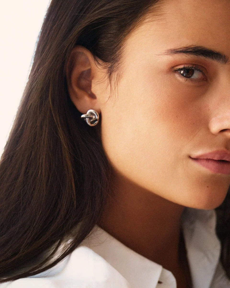 Teräksiset Edblad Infinity Knot Studs L Silver -solmukorvakorut 129856 mallin korvassa
