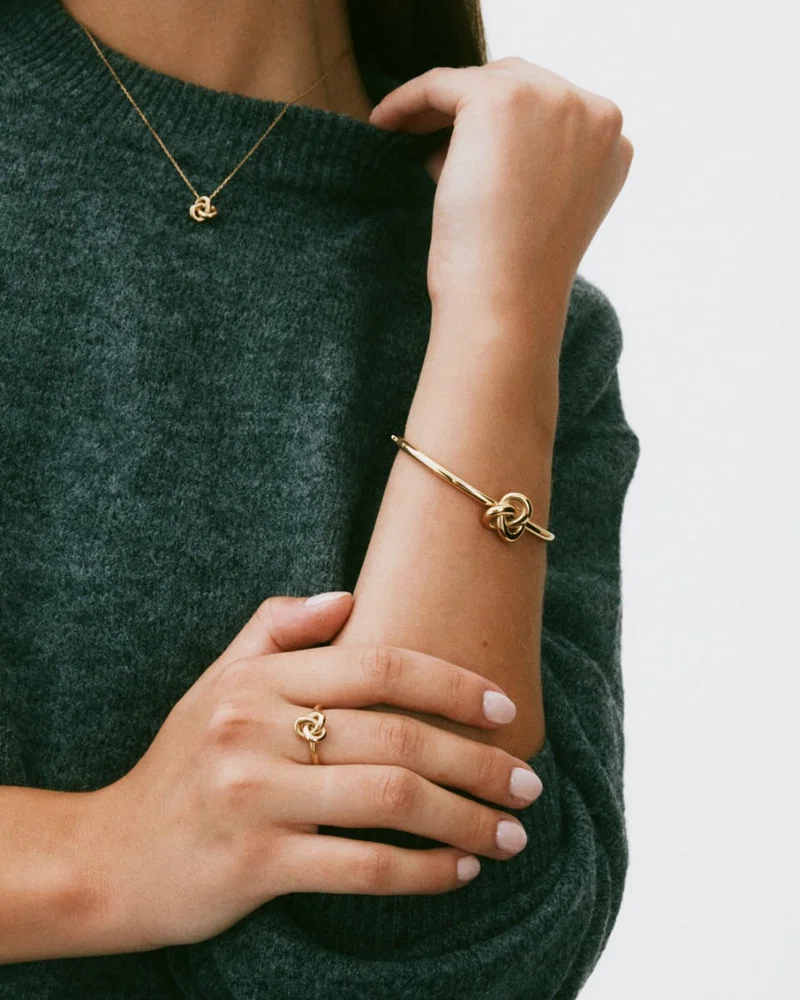 Kullattu Edblad Infinity Knot Bangle Gold -rannerengas 129917 mallin ranteessa