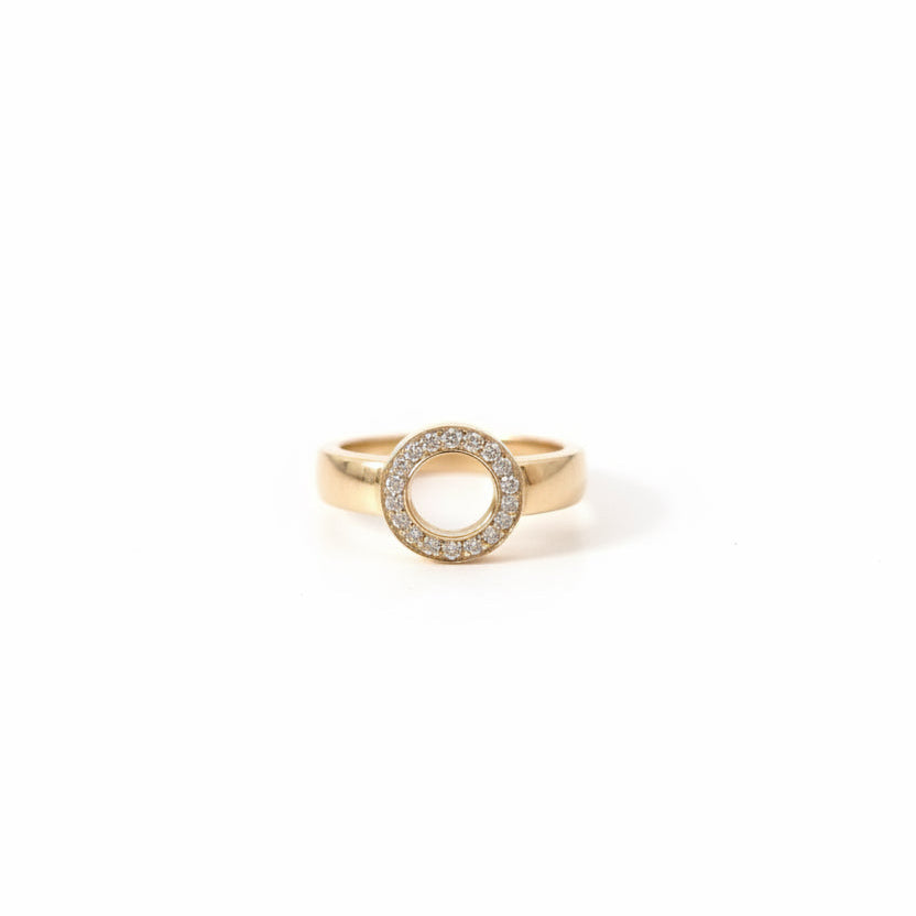 Närbild på Efva Attling Ring On Ring vigselring framifrån, där 17 diamanter bildar en rund cirkel med ett öppet center.