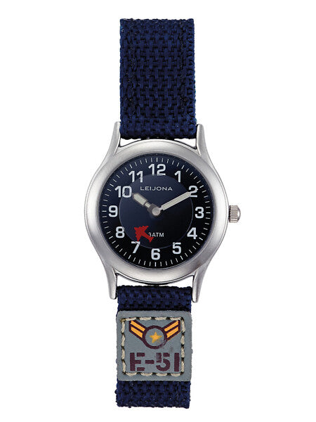 Leijona Junior Pilot Navy Blue 5223-232 barnklocka har en rund, mörkblå urtavla med silverfärgade numeriska index och självlysande visare. Sekundvisaren är ett litet rött flygplan som rör sig dygnet runt enligt sekunderna. Boetten är silverfärgad och remmen är mörkblå och har ett märke med flyer-tema.