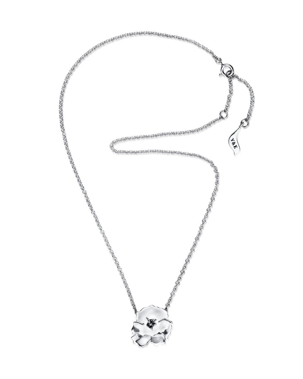 Efva Attling Anemone 10-100-02339 halsband har en tunn silverkedja och en blomformad prydnad. Den centrala delen av blomman har mörknat silver