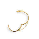 En tydlig illustrationsbild som visar låsmekanismen och öppningen på det stela bangle-armbandet till Mockberg Belle Oval Petite Gold.