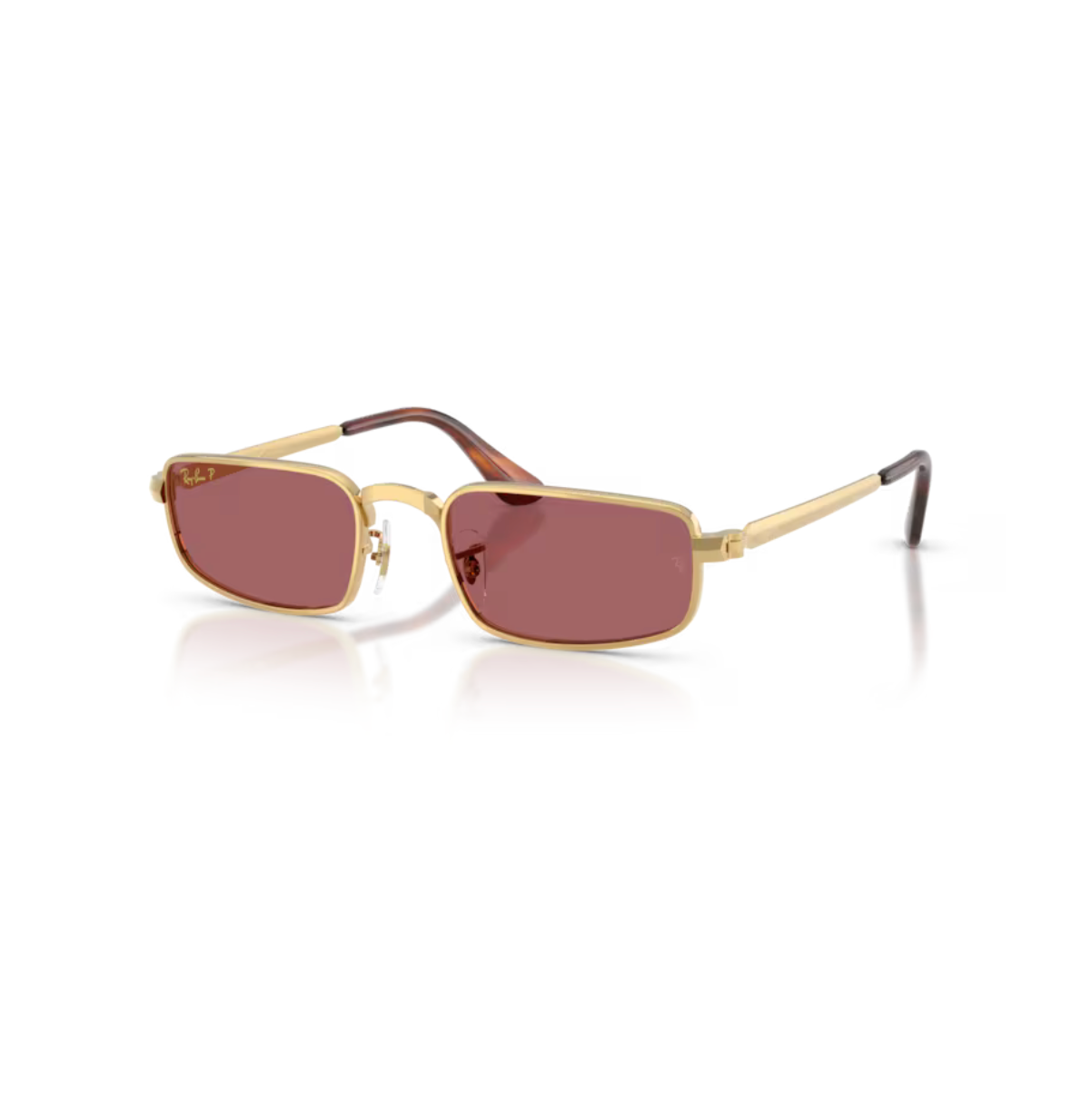 Ray-Ban RB3927 By A$AP Rocky solglasögon fotograferade snett framifrån, som visar de Pillow-formade guldbågarna och de violetta linserna.