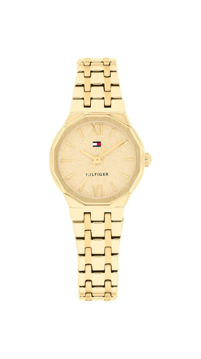 Guldfärgad Tommy Hilfiger TH1782886 damklocka med smäcker 25 mm boett, stållänk och en unik 12-kantig mutterformad lynett.