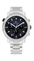 Tommy Hilfiger Troy TH1792104 herrklocka har en rund, blå urtavla med datum-, veckodag- och 14/24 h-visning samt silverfärgade självlysande index och visare. Ramen, boetten och remmen är silverfärgade.
